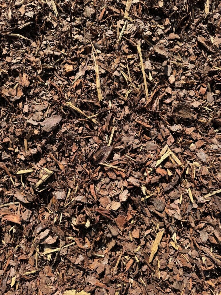 Close-up of dark brown mulch with wood chips and bark pieces.