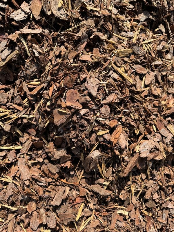 Close-up of shredded brown mulch on the ground.
