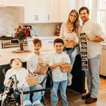 Happy family of six posing joyfully in their kitchen.