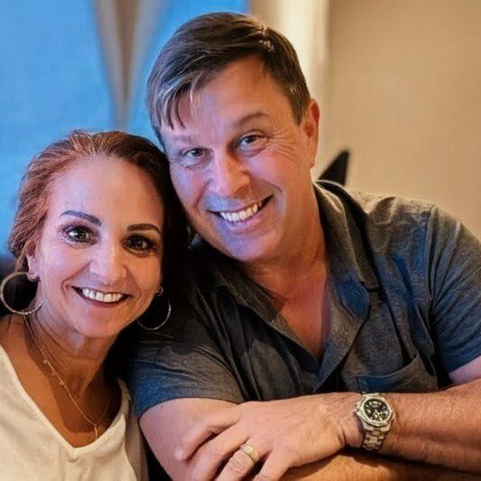 Smiling couple sitting closely together indoors.